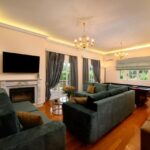 Spacious living room with fireplace and garden views in luxury Corfu villa for sale