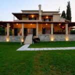 Exterior view of three-level villa with traditional architecture and pool