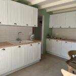 Open-plan kitchen in a renovated home in Alepou, Corfu, with contemporary appliances and finishes.