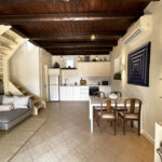 Open-plan kitchen and lounge area with a cozy fireplace on the ground floor of the house in Gastouri