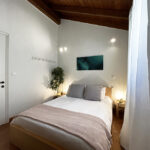 Upstairs bedroom with a balcony offering countryside views in the renovated house in Gastouri