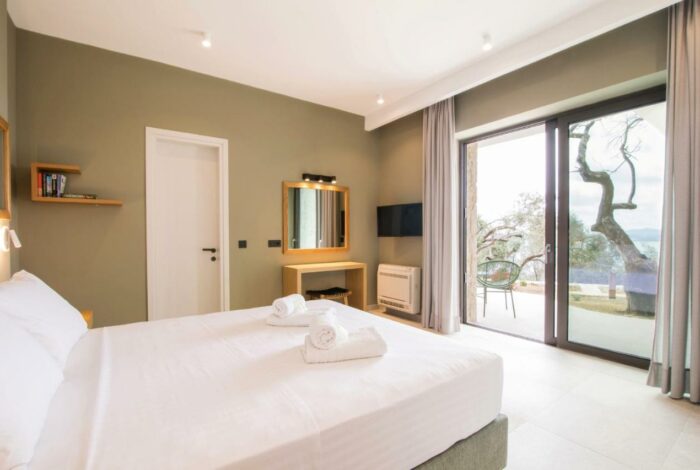 Tranquil villa bedroom with large windows overlooking the Ionian Sea