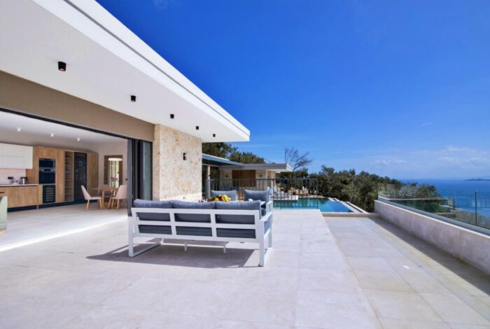 Outdoor dining area with sea view and natural stone backdrop