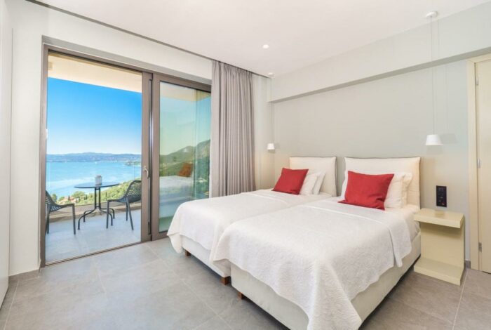 Spacious bedroom with sea-facing balcony in Corfu stone villa