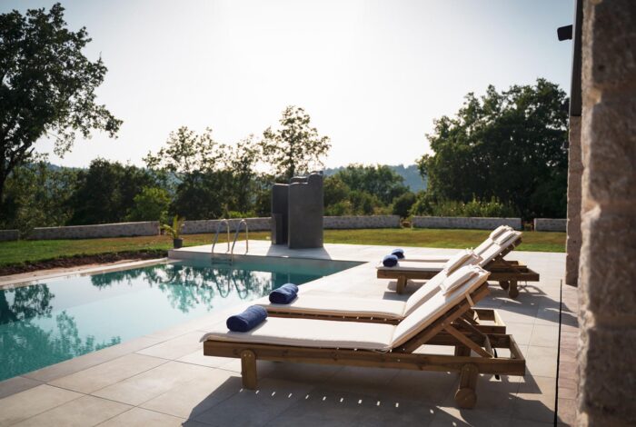 Pool and outdoor relaxation area with sunbeds at Corfu villa