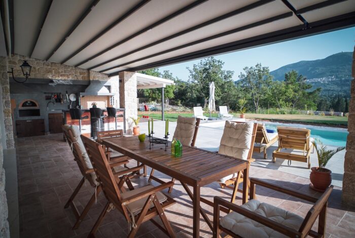Spacious outdoor sitting area with comfortable seating and garden views in Corfu villa