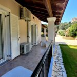 Covered balcony, well-maintained garden and lawn in villa near Agios Georgios beach in Corfu