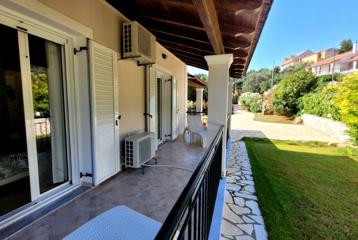 Covered balcony, well-maintained garden and lawn in villa near Agios Georgios beach in Corfu