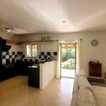 Open-plan living and dining room with garden views in villa for sale in Corfu