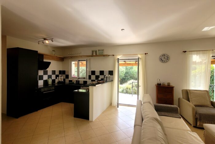 Open-plan living and dining room with garden views in villa for sale in Corfu