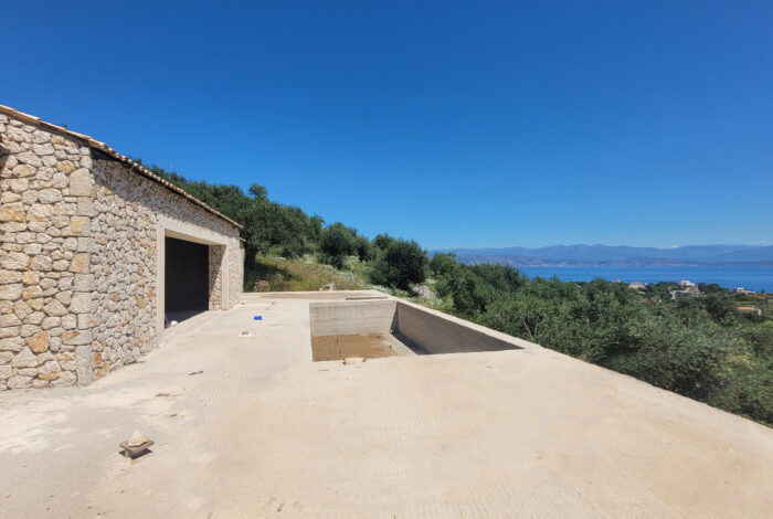 Exterior stone facade of unfinished villa with private hillside plot