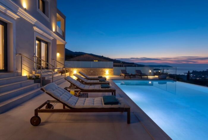 Infinity pool and terrace beautifully lit under the night sky in Corfu villa