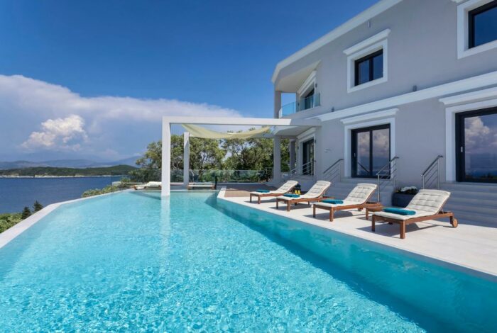 Elegant sunbeds aligned beside infinity pool with amazing sea views