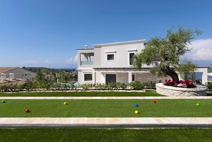 Beautifully landscaped garden with manicured lawns and paved pathways surrounding luxury villa