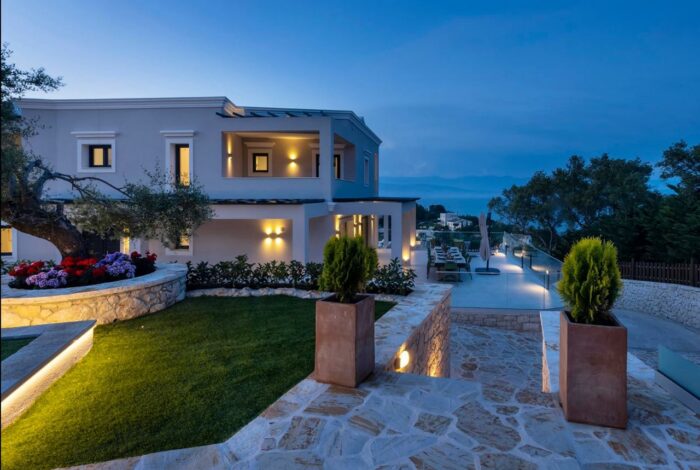 Warm architectural lighting highlighting stone walls and garden pathways at night