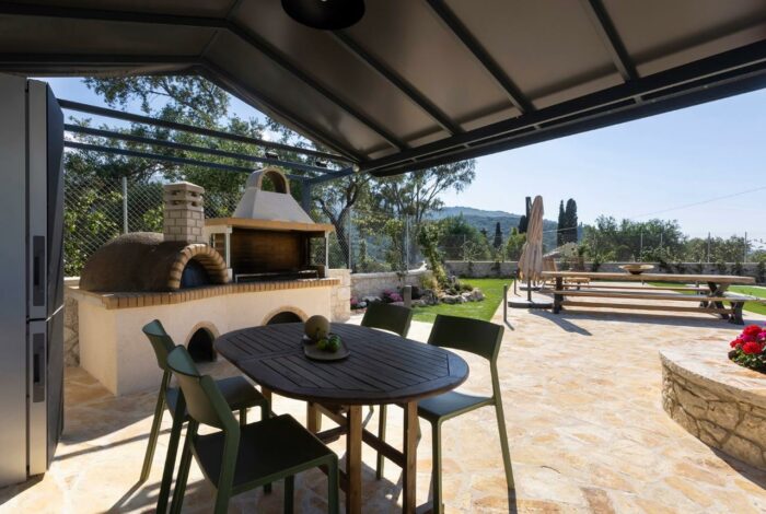 Outdoor BBQ area with dining space for entertaining guests in Kassiopi villa