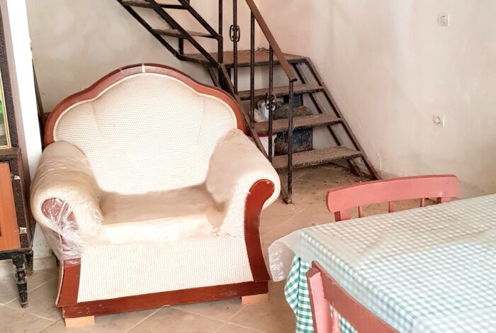 Open plan kitchen and living area in need of full renovation in Chlomos property