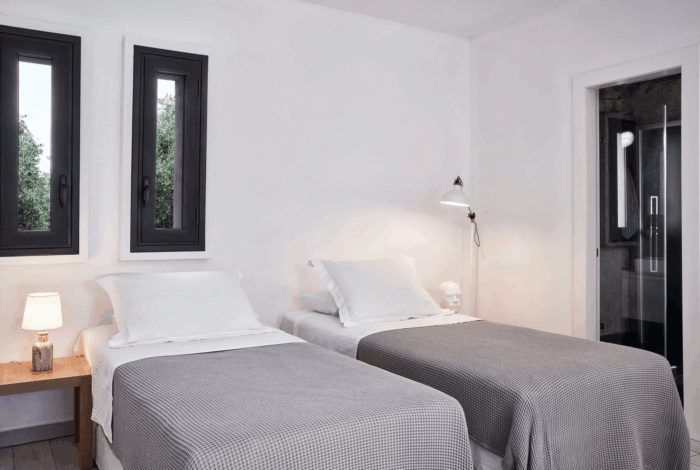 Contemporary bedroom with large windows and serene sea view in Corfu villa