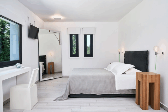Contemporary bedroom with large windows and serene sea view in Corfu villa