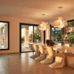 Open-plan living and dining space with designer furniture and panoramic views