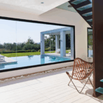 Elegant living area with fireplace and floor-to-ceiling windows overlooking Corfu’s coastline