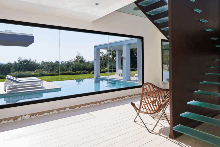 Elegant living area with fireplace and floor-to-ceiling windows overlooking Corfu’s coastline
