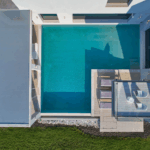 L-shaped private swimming pool with sun loungers and lush surroundings in Viros, Corfu