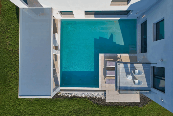 L-shaped private swimming pool with sun loungers and lush surroundings in Viros, Corfu
