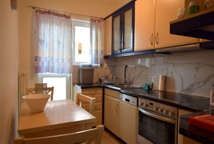 Fully renovated kitchen with balcony access – Kypseli property