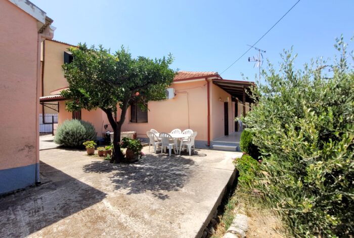 Paved courtyard with seating area between two detached houses in Pagi, Corfu