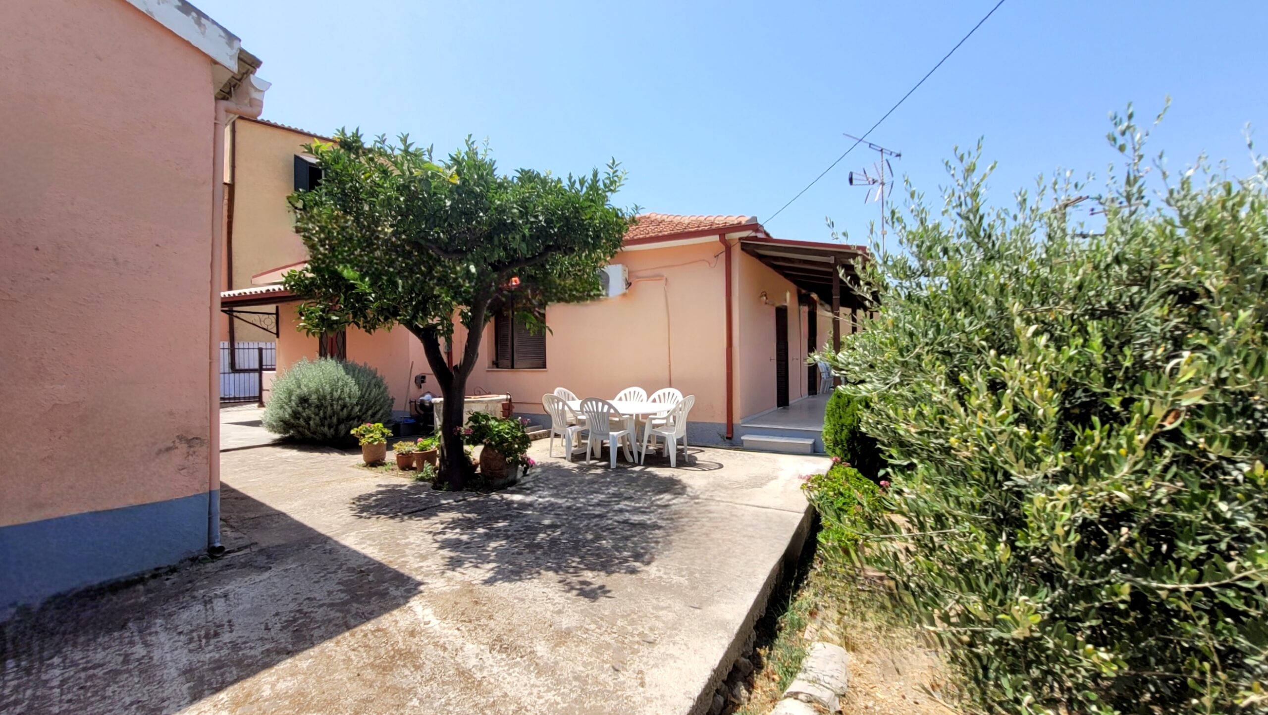 Paved courtyard with seating area between two detached houses in Pagi, Corfu