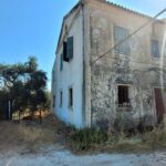 Exterior view of two-storey house with stone façade and tiled roof