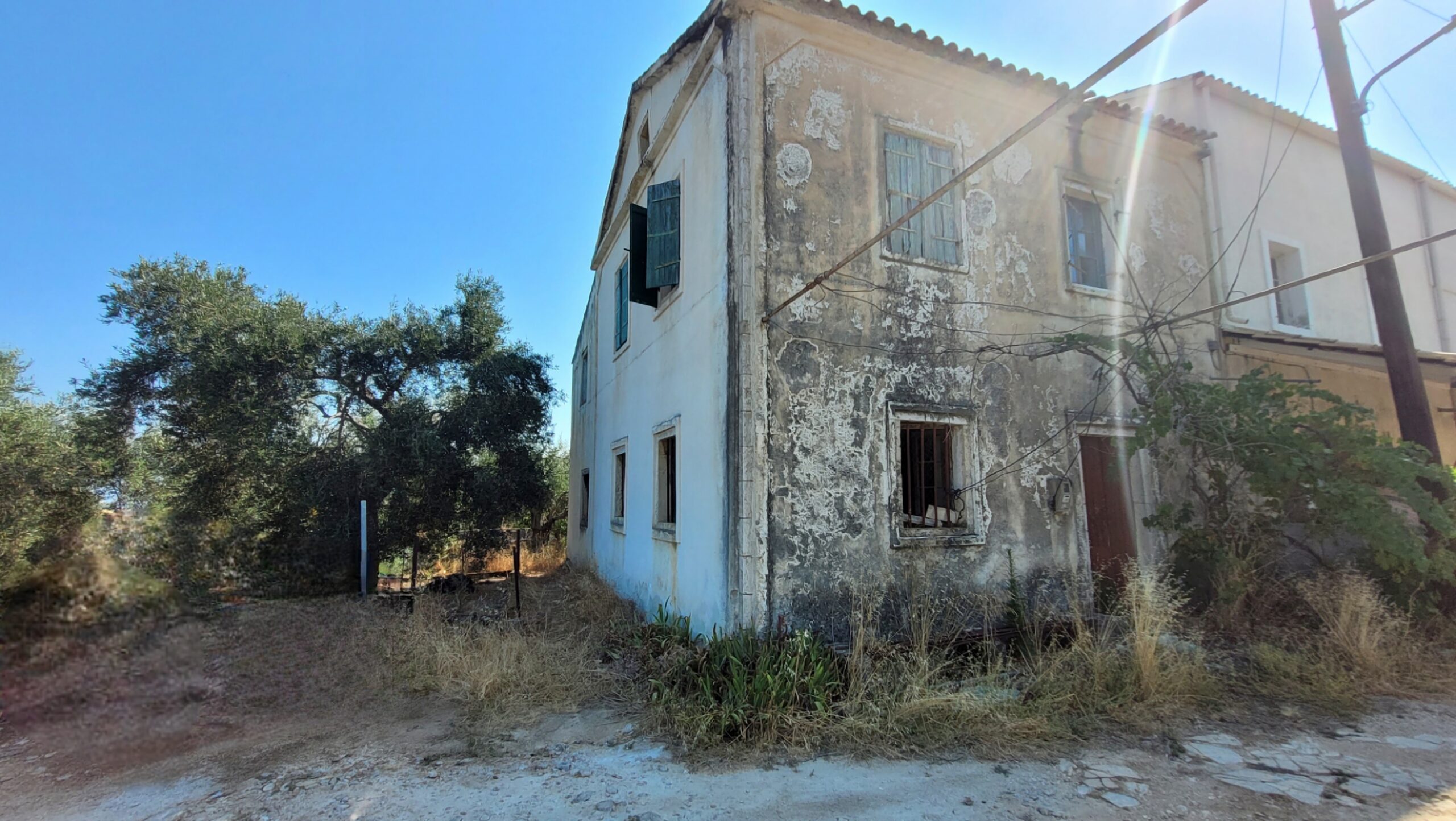 Exterior view of two-storey house with stone façade and tiled roof