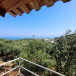 First-floor balcony overlooking lush nature and distant sea