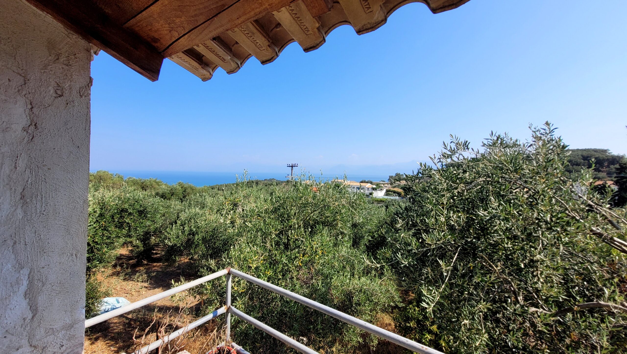 First-floor balcony overlooking lush nature and distant sea