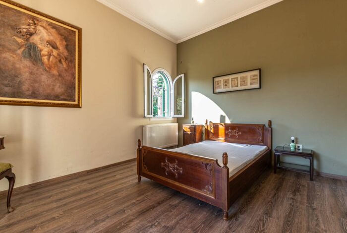 Second bedroom with ample natural light and traditional wooden furniture