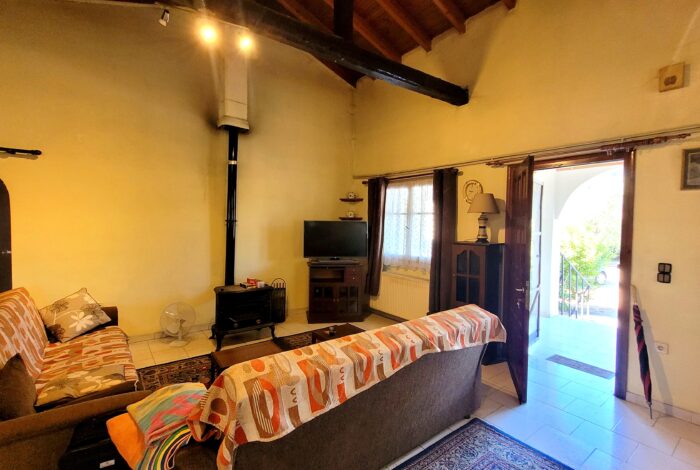 Spacious open-plan living room with wood-burning stove in Linia Corfu home for sale