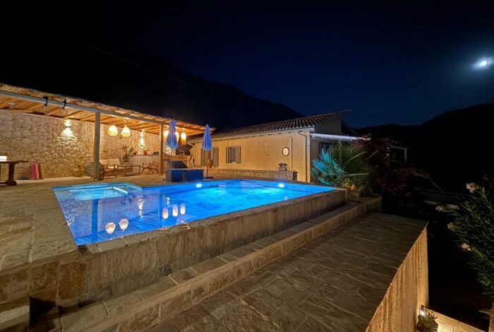 Night view of illuminated swimming pool in Paramonas Corfu villa