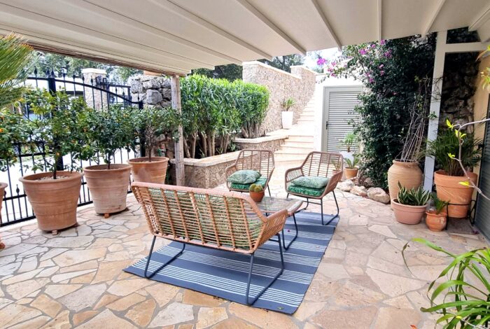 Outdoor seating area with gardens and sea view in Corfu villa