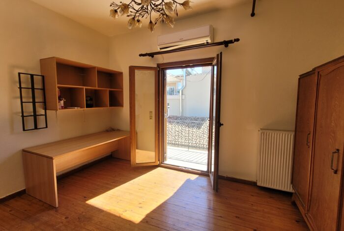 Bedroom with wooden balcony doors and shutters