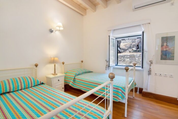 Bright double bedroom with wooden floors in Paxos villa for sale