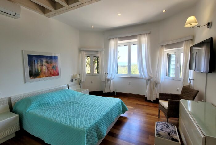 Master bedroom with en suite bathroom in Paxos real estate listing