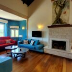 Living room with stone fireplace and wooden floors in Paxos villa