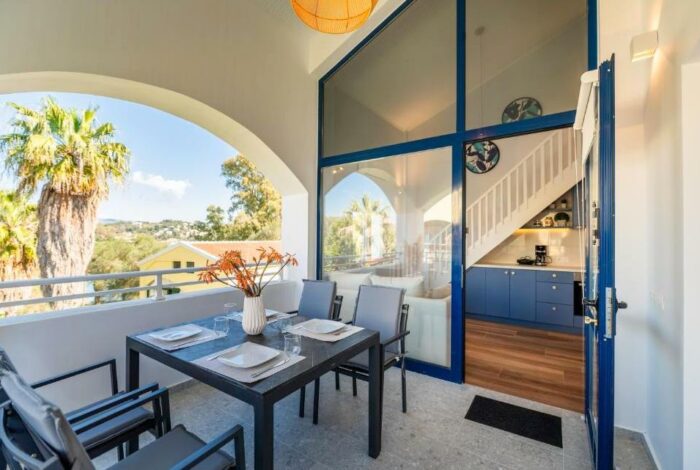 Outdoor breakfast and dining space at the balcony overlooking the garden and swimming pool