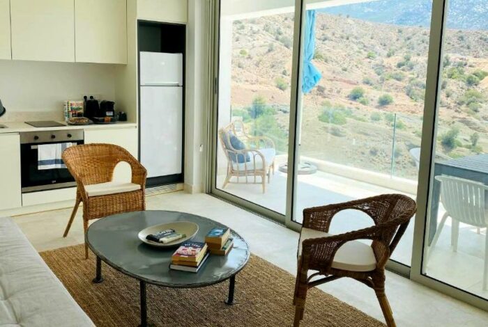 Bright studio interior with open-plan layout and sea view window