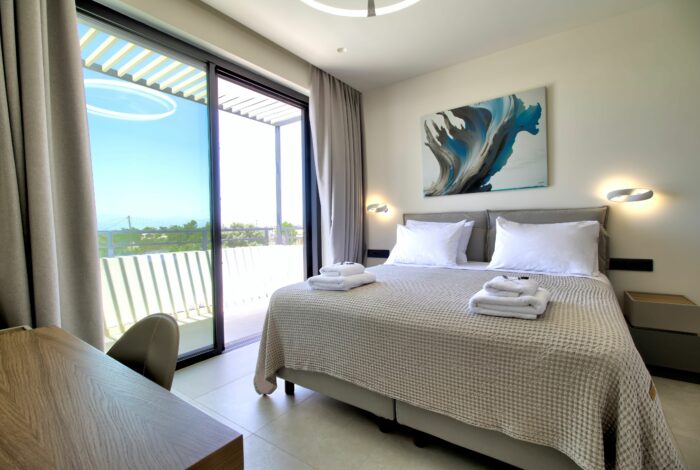 Modern bedroom with glass doors and views to the sea