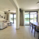Elegant dining area with floor-to-ceiling windows overlooking pool