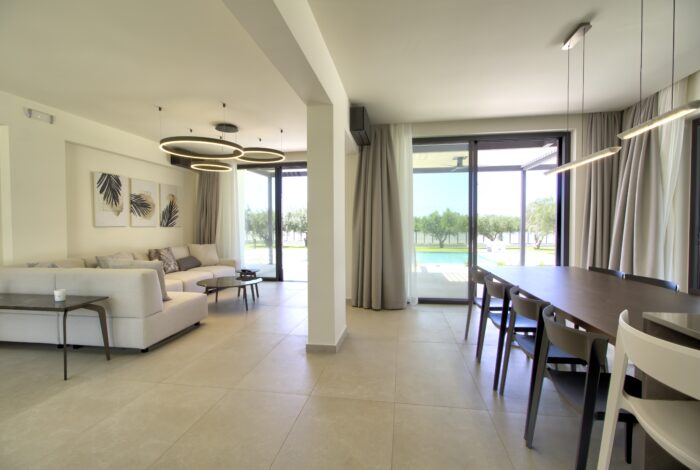 Elegant dining area with floor-to-ceiling windows overlooking pool