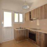 Contemporary fitted kitchen with built-in cabinets and extractor hood in Piraeus apartment