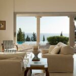 Open plan living room with fireplace and large balcony doors facing the sea